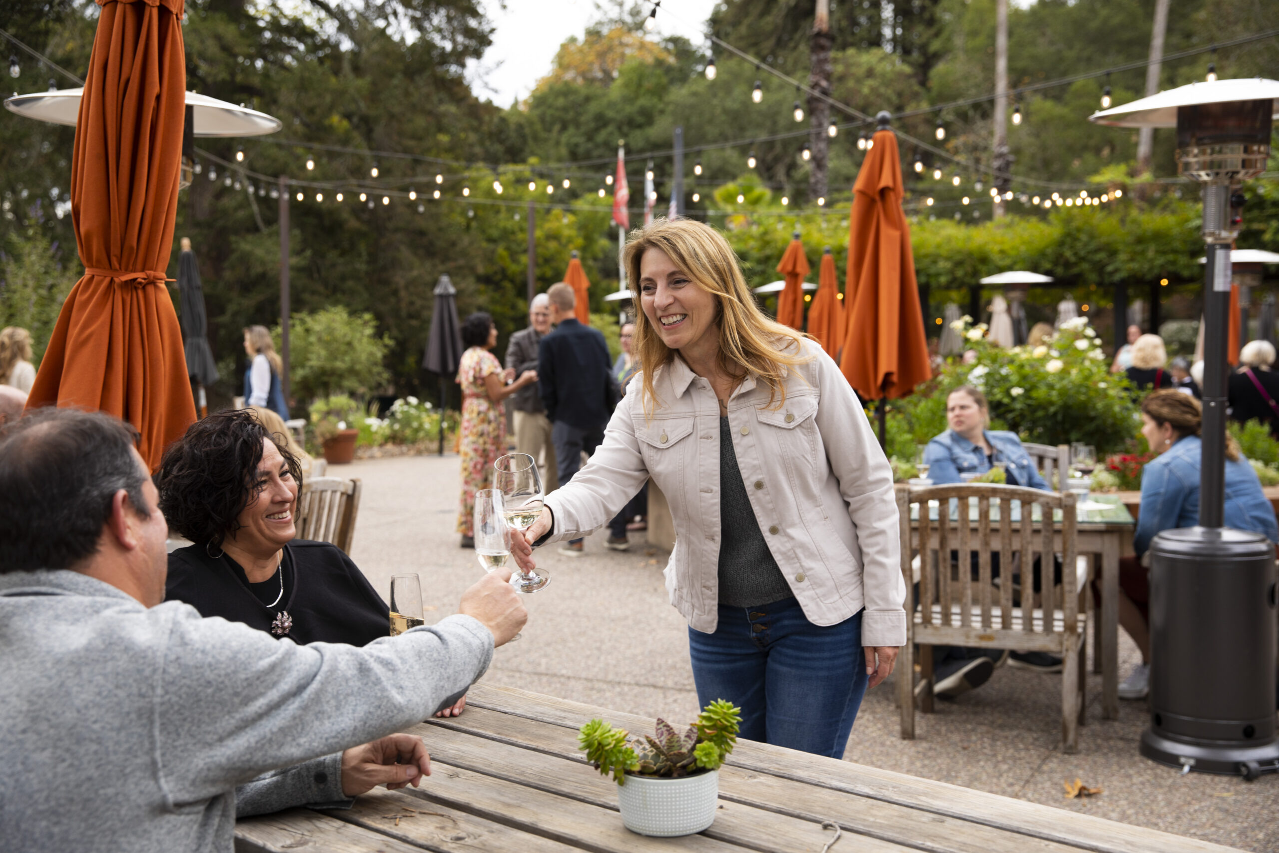 Benziger winemaker clinking wine glasses with an individual at an event
